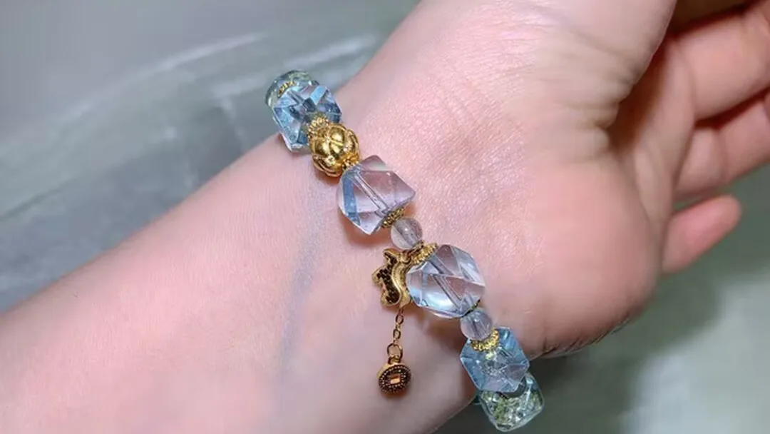 戴在手腕上的天然蓝托帕手链，刻面冰川蓝珠子闪烁光芒