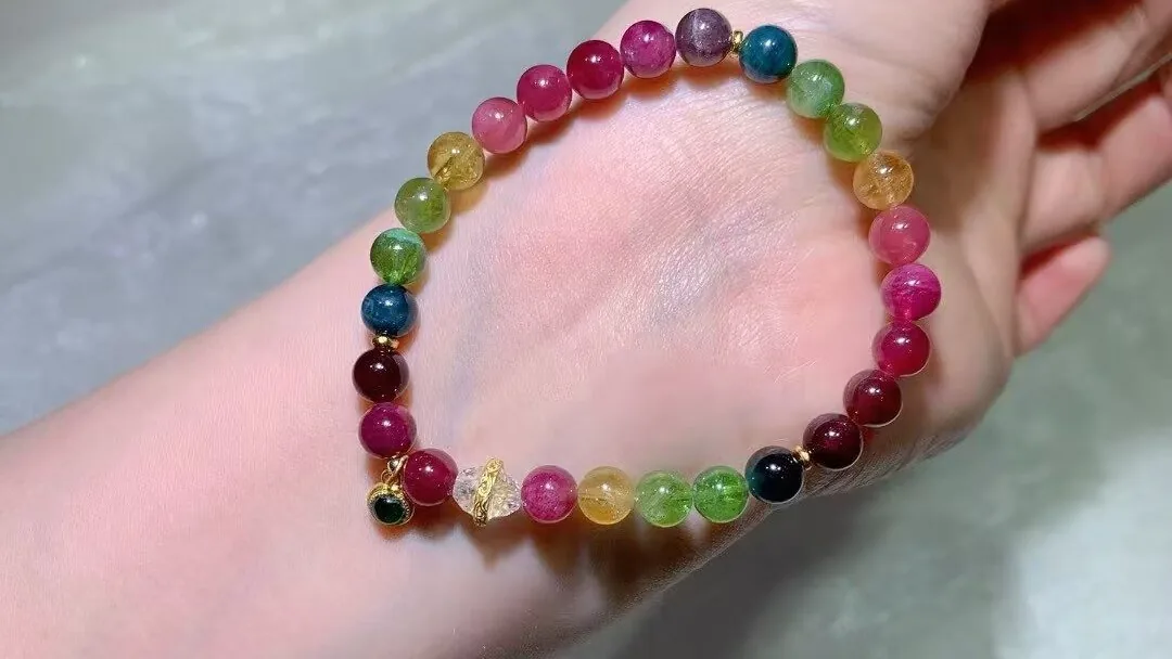 戴在手腕上的天然糖果碧玺手串，粉、红、绿、黄、蓝色珠子
